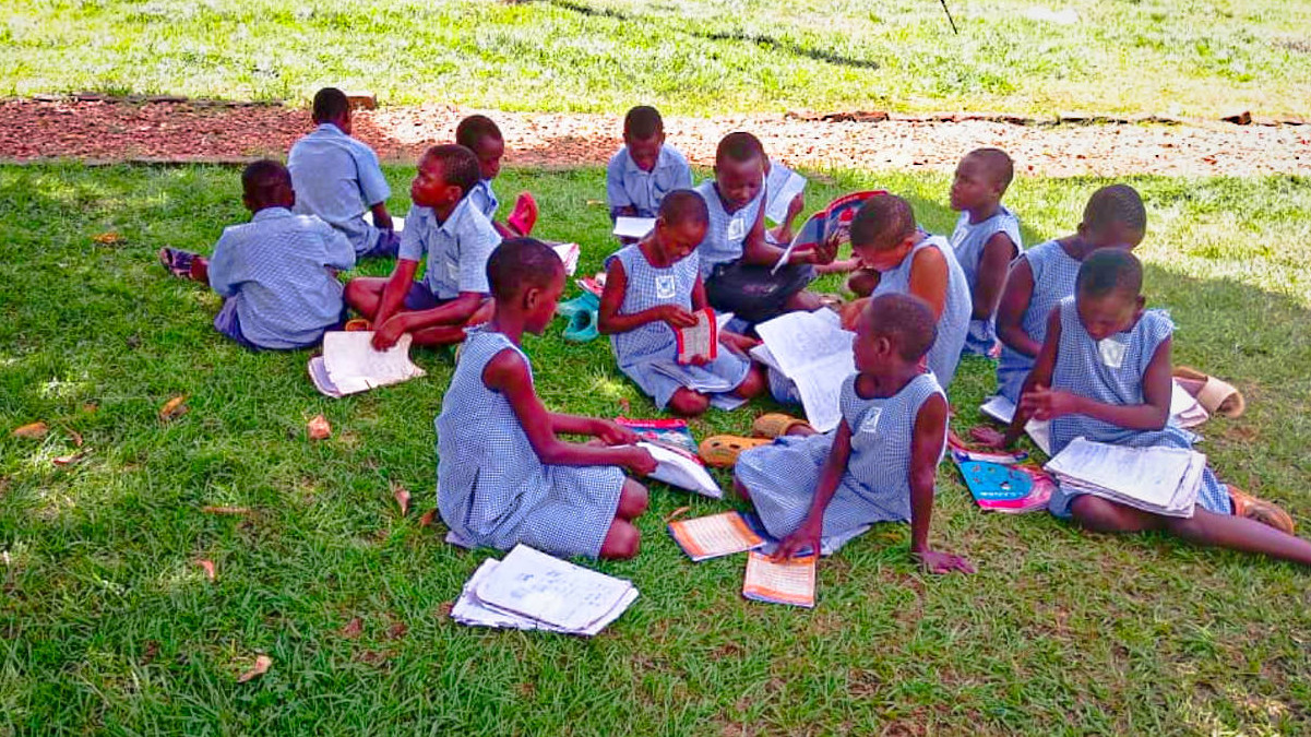 kids sitting on the grass at abba fathers house